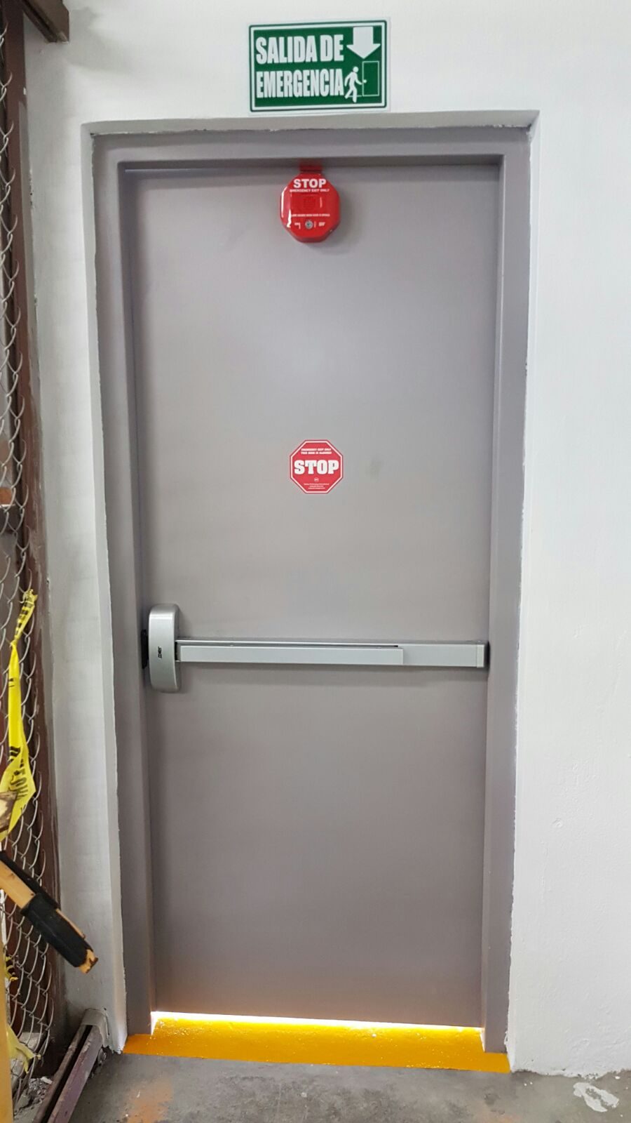Puerta de salida de emergencia BLINSA con señalización y barra antipánico